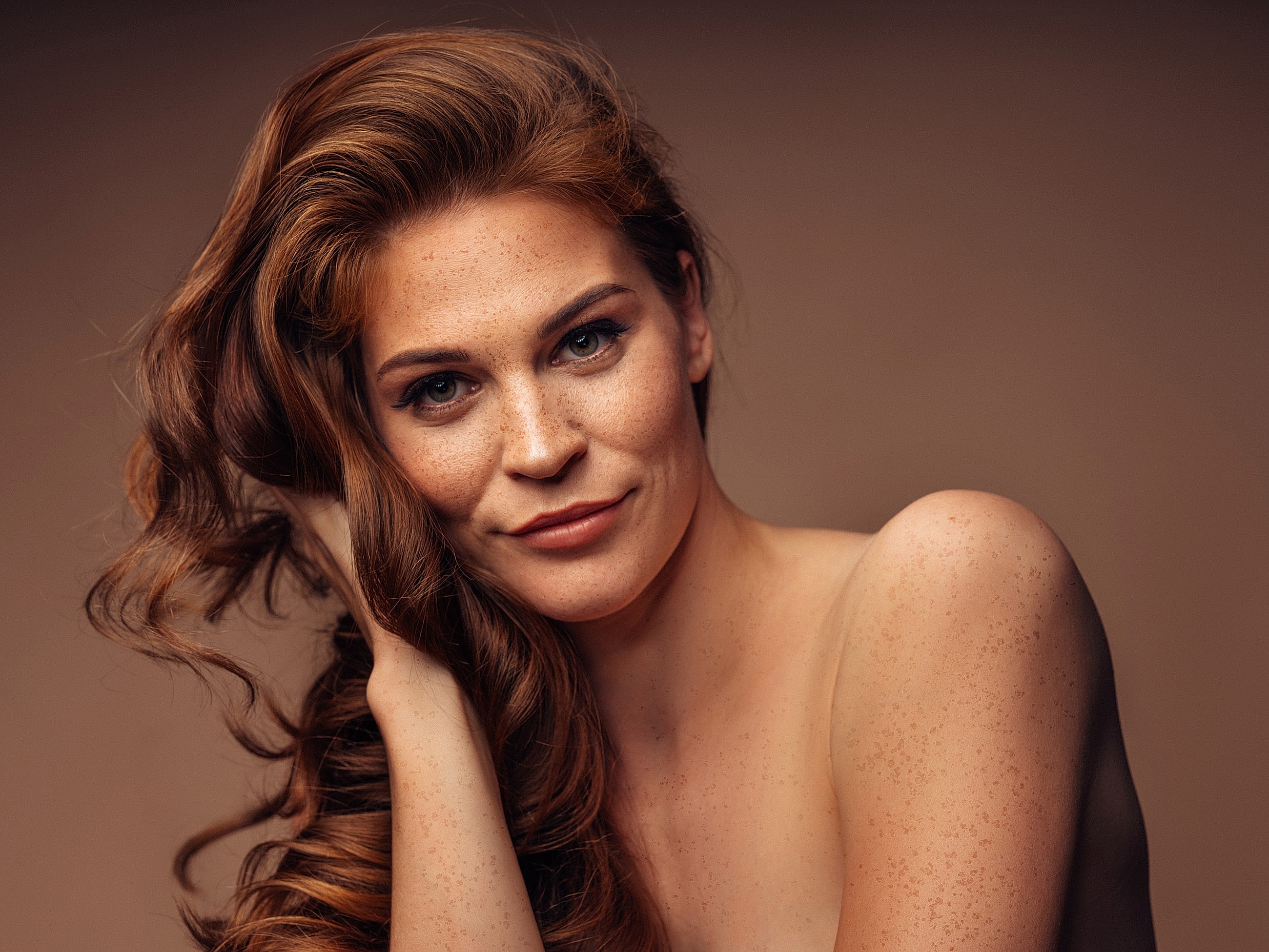 Woman with long, wavy hair and freckles.